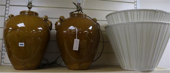 A pair of Chinese style treacle glazed pottery table lamps, with shades, 40cm